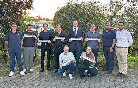 Sieben Personen mit Urkunden und ihre Ausbilder